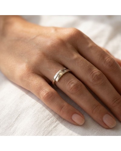 Alliance TOI + MOI: chevalière en or avec diamant solitaire porté sur le doigt, fond neutre.