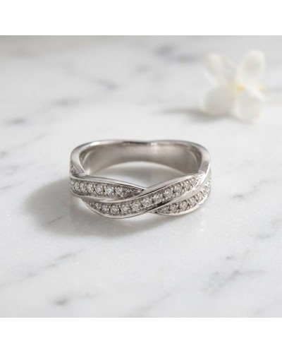 Alliance TRESSE empierrée en or blanc avec diamants, motif croisé élégant sur fond marbré.