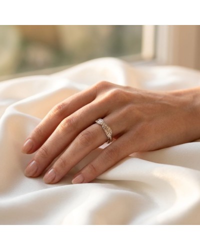 Alliance empierrée en or sur doigt féminin, pavée de diamants, posé sur satin blanc.
