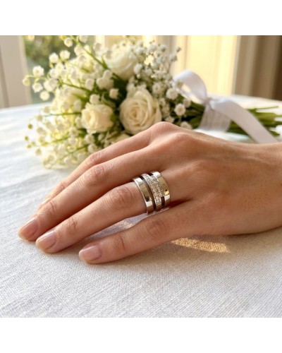 Alliance TRILOGIE Femme en or: bague argentée avec trois anneaux, l'un serti de petits diamants, posé sur une main au bouquet bl