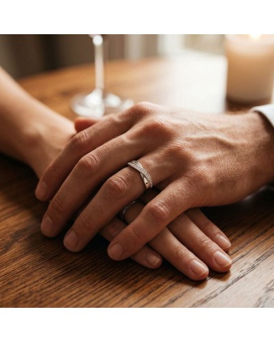 Alliance TRESSE demi-empierrée (diamants) Homme en or: deux mains jointes portant une bague complexe au doigt, sur table en bois