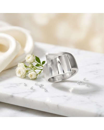 Bague TAFFETAS en argent moderne sur marbre, avec petites roses blanches et bijoux scintillants autour.