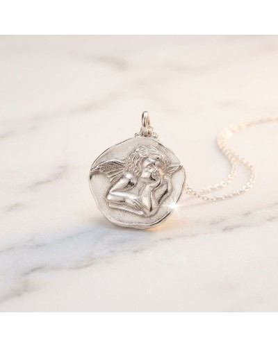 Pendentif rond argenté avec gravure d’un ange ailé, chaîne fine en métal, bijoux délicat et scintillant.