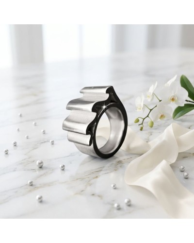 Bague ONDULATION en métal argenté avec motifs ondulés, posée sur marbre, ornée de perles et d’orchidées blanches.