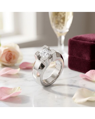 Bague JERK en argent avec pierre centrale carré brillant, design moderne, posée sur une surface marbrée avec pétales et boîte ro