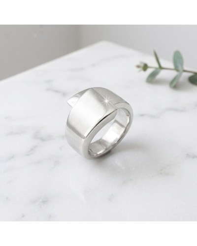 Anneau argenté moderne avec fini brushed, sur fond marbre; éclat discret sur le bord, nom du produit Bague TOI SUR MOI mentionné