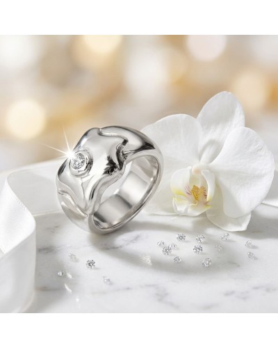 Bague NUAGE en argent brillant avec petit diamant, posée près d’une orchidée blanche et petites pierres scintillantes.