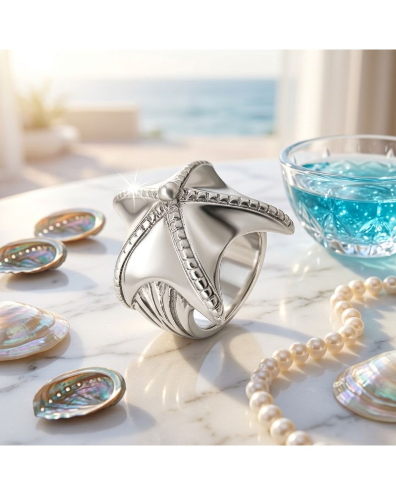Bague ÉTOILE DE MER en argent, design mariné avec étoile marine sculptée et détails texturés, posé sur une table près de perles