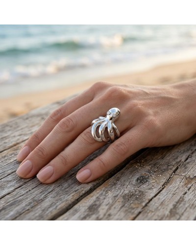Bague POULPE en argent brillant, motif tentacules abstraits ornés de petites pierres sur le bord d’une main sur bois près de la