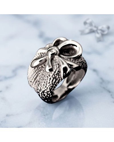 Bague en métal argenté en forme de fleur avec pistil détaillé et texture gravée, reposant sur une surface marbrée. Produit PRESE