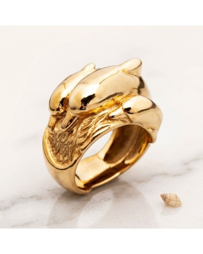 Bague dorée épaisse au motif sculpté, style animalier, forme organique et brillant, avec petit coquillage à côté. Ultra glamour,