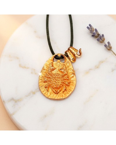 Pendentif zodiaque Cancer en métal doré avec cordon noir et fermoir offert, gravure détaillée sur pierre ovoïde.