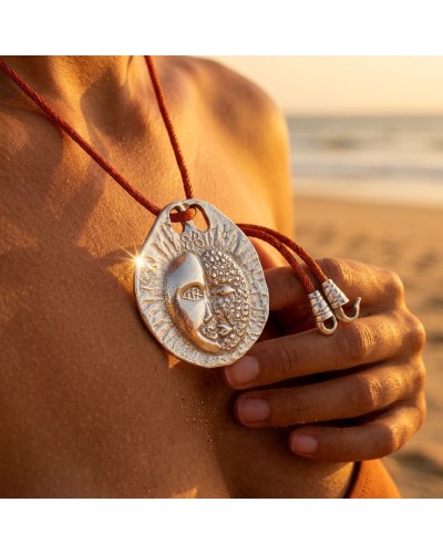 Pendentif rond argenté gravé soleil et visage, sur cordon orange avec fermoir offert à la plage. GEMEAUX zodiac coin.