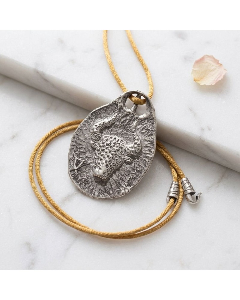 Pendentif taureau zodiaque en métal argenté avec cordon doré et fermoir offert, motif texture sculptée diagonal sur support oval