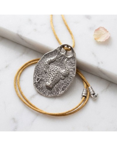 Pendentif taureau zodiaque en métal argenté avec cordon doré et fermoir offert, motif texture sculptée diagonal sur support oval