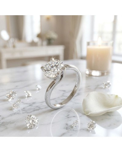Bague HALMAHERA en argent avec diamant rond taille brillante sur une table marbrée, décor floréal et bougie en arrière-plan.