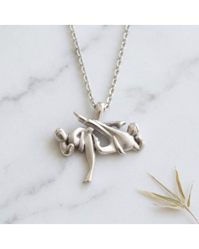 Pendentif en métal argenté Taekwondo avec figure de pratiquants en mouvement, chaîne offerte.