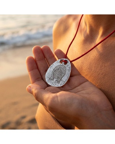 Pendentif zodiaque Vierge argenté, relief detailé, sur cordon rouge avec fermoir offert, près de la plage.