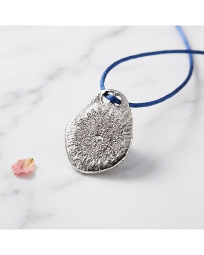 Pendentif zodiaque Lion argenté à disque texturé, porté sur cordon bleu avec fermoir offert.