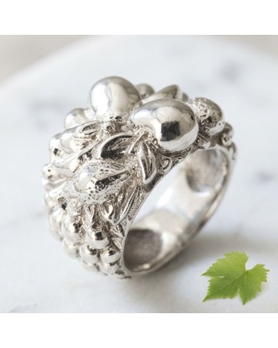 Bague SALADE DE FRUITS en argent massif avec motif floral et gravures, près d’une feuille verte, arrière-plan clair.