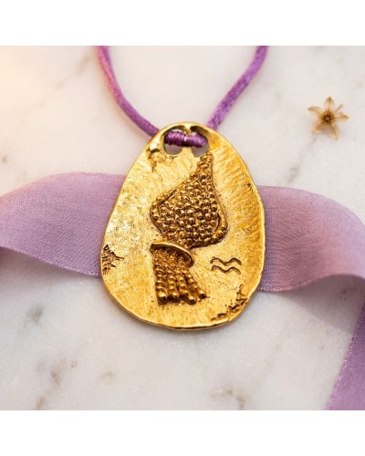 Pendentif zodiaque Verseau en or avec cordon violet et fermoir offert, motif plume/texturé sur plaque ovalisée.