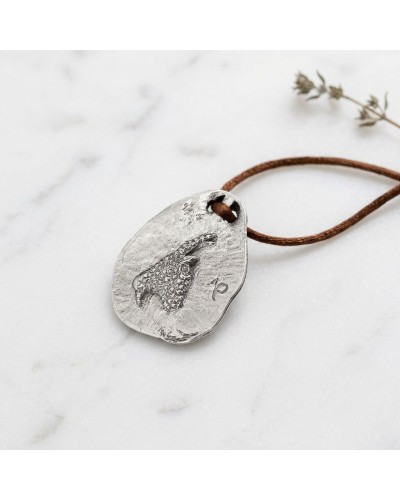 Pendentif zodiaque CAPRICORNE en métal argenté texturé, gravé avec cordon brun et fermoir offert.