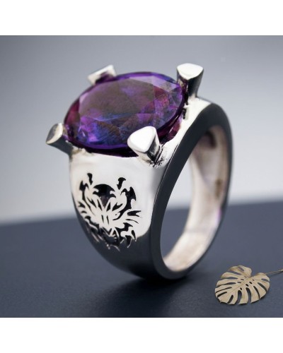 Anneau chevalière SUMATRA pierre violette facettée sur monture argentée avec motif floral gravé à la base.