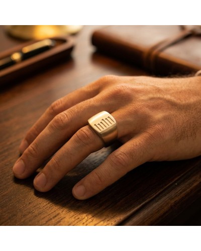 Bague KEKAYAAN argentée sur le doigt, design géométrique gravé de fines barres verticales.