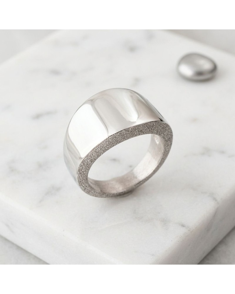 Bague CLEAN en métal argenté avec garniture extérieure satinée et pavage fin, posée sur une surface blanche.