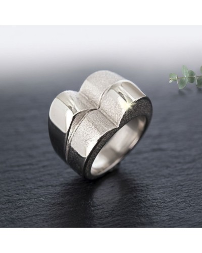 Bague BOSSA NOVA en métal argenté avec motif géométrique rehaussé par une texture mate sur fond noir.