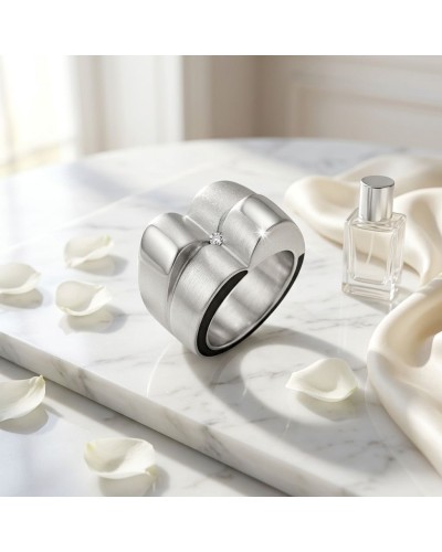 Bague BOSSA NOVA en métal argenté, design biseauté triple rangs avec pierre centrale, posé sur marbre blanc ambiance lumineuse.