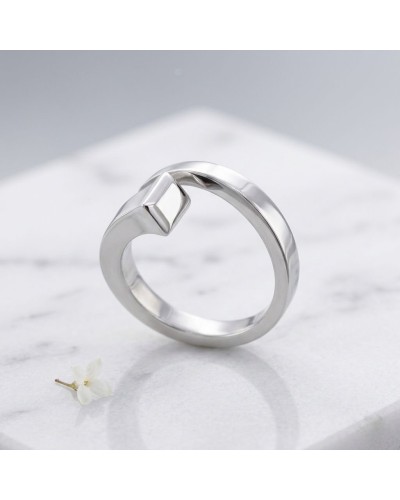 Bague CLOU femme en argent rhodié, conception moderne with relief motif sur anneau argenté posé sur pierre blanche.