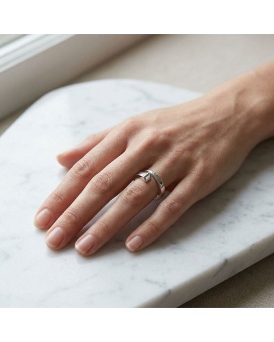 Bague CLOU femme en argent rhodié portée sur le doigt, vue légère sur une table en marbre.