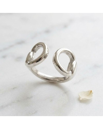 Bague MORS femme en argent rhodié ouverte, finition miroir sur fond marbré blanc.