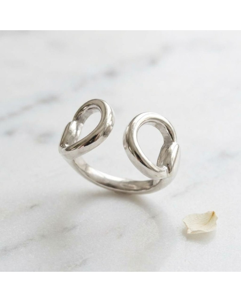 Bague MORS femme en argent rhodié ouverte, finition miroir sur fond marbré blanc.