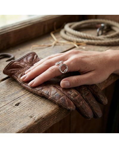 Bague MORS femme en argent rhodié posée sur une main, décorée de motif circulaire, portée sur un doigt; gants en cuir et corde e
