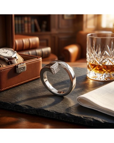 Bague CLOU homme en argent rhodié sertie de 20 oxydes blancs posée sur une table à côté d’un verre et d’un veston en cuir.