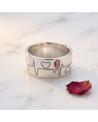 Alliance BEATING LOVE femme en or: bague argentée gravée de motif électrocardiogramme et cœur, posé sur marbre avec pétale rouge
