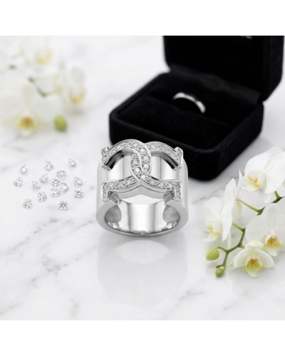 Bague MARECHAL en argent rhodié sertie de 27 oxydes blancs, motif pavé élégant, présentée devant boîte noire et fleurs.