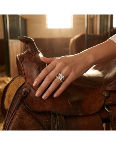 Bague MARECHAL en argent rhodié sertie de 14 oxydes blancs portée sur l’annulaire droit d’une main féminine sur une selle en cui