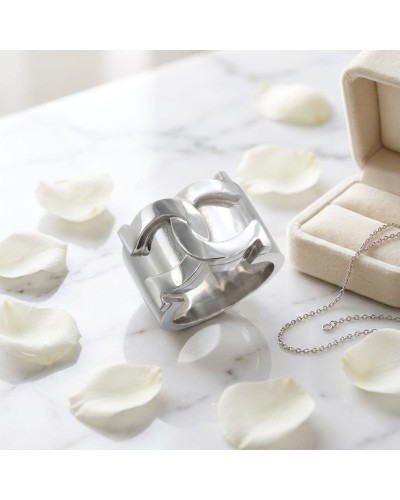 Bague MARECHAL en argent rhodié au dessus d’un marbre, entourée de pétales blancs et d’un coffret à bijoux avec chaîne.