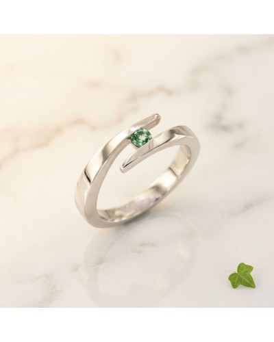 Alliance croisée en or avec tourmaline verte au centre, design moderne et élégante.