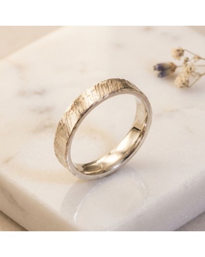 Alliance effet strié pour femme en or - bague en or avec texture naturelle, posée sur pierre claire.