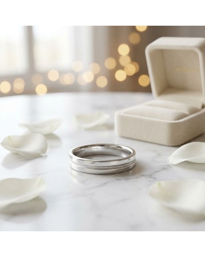 Alliance intérieur sablé pour femme en or: bague en métal argenté sur marbre, boîte à bijoux beige en arrière-plan, pétales blan