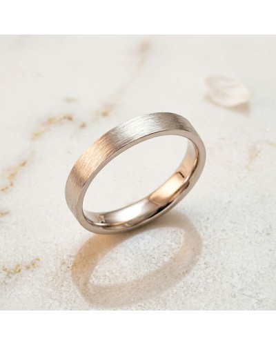 Alliance effet griffé pour femme en or, bague bicolore dorée et argentée, texture satinée sur fond clair.