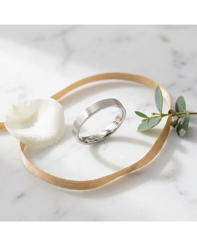 Alliance griffée pour femme en or argenté, sur ruban doré, avec feuille et pétale blanche.
