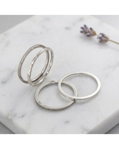 Alliance à effet de matière pour homme en or: bagues argentées texturées sur pierre blanche, fleurs lavande à l’arrière.