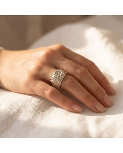 Alliance FLAMME pour femme en or: bague argentée texturée portée sur le doigt gauche.