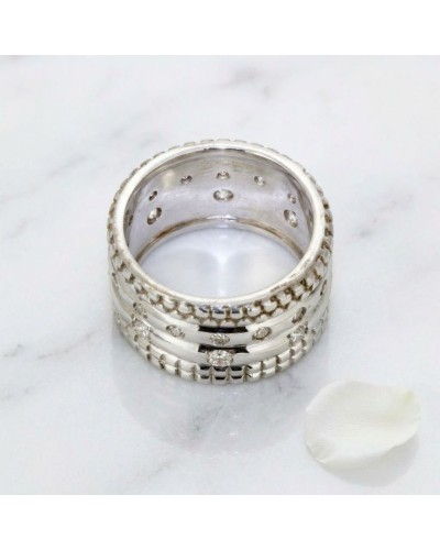Alliance LASSO pour femme en or sertie de 24 diamants: bague large argentée avec cannelures et diamants, posée sur marbre.