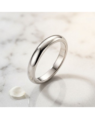 Alliance Basic Bombée femme en or - bague lisse et brillante sur marbre clair, pétale blanche au côté.